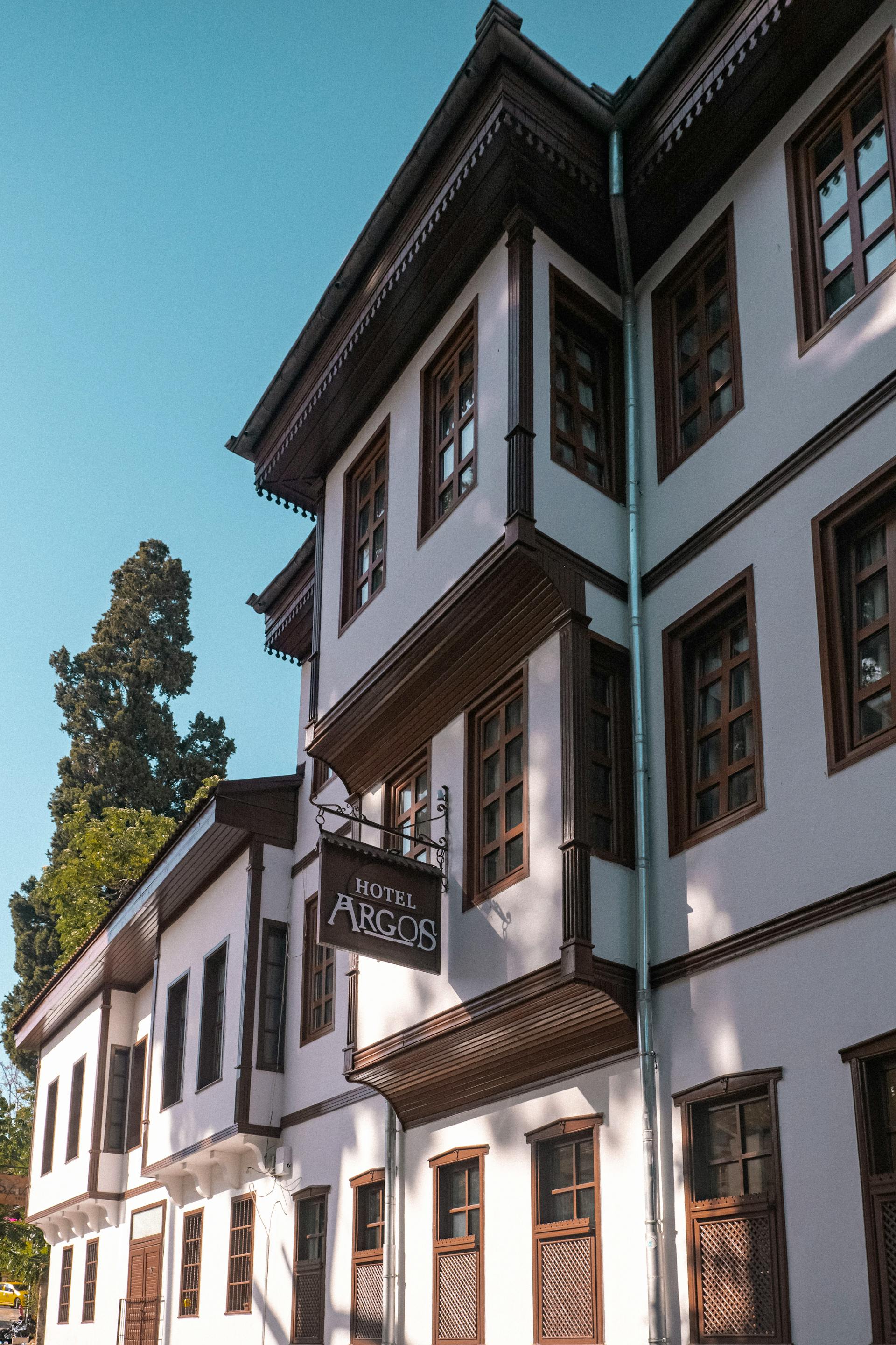 Classic white residential building under a clear blue sky, suggesting refined senior living architecture